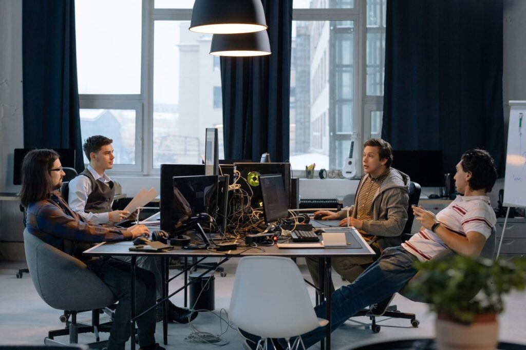 Young professionals collaborating in a vibrant office setting with computers and documents.